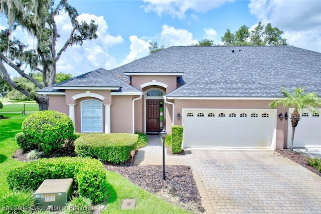 3013 Royal Oaks Ct, Sebring, FL 33875 - view of front of property featuring stucco siding, an attached garage, decorative driveway, and roof with shingles