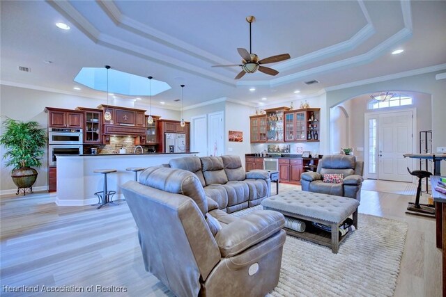 3013 Royal Oaks Ct, Sebring, FL 33875 - living area featuring a raised ceiling, bar, recessed lighting, ceiling fan, and light wood-style flooring