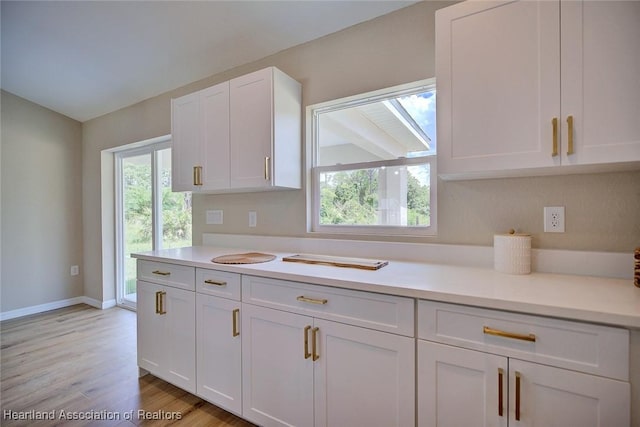 4001 Simca St, Sebring, FL 33872 - kitchen featuring white cabinetry, light countertops, light wood-style flooring, and baseboards