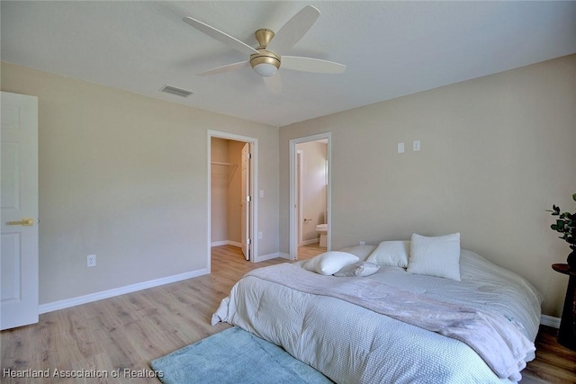 4001 Simca St, Sebring, FL 33872 - bedroom with wood finished floors, baseboards, a spacious closet, a ceiling fan, and ensuite bathroom