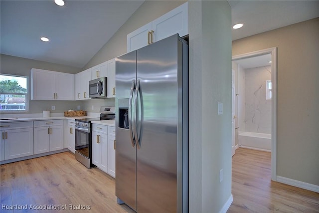 4001 Simca St, Sebring, FL 33872 - kitchen with appliances with stainless steel finishes, white cabinets, light countertops, light wood-style floors, and lofted ceiling