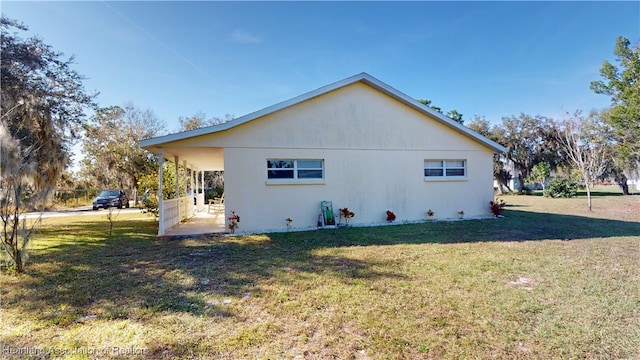 view of side of home with a yard