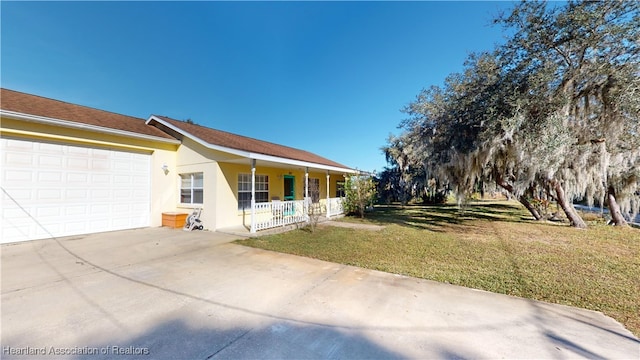 view of front of home featuring a front yard, a porch, and a garage