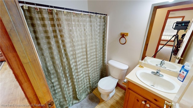 bathroom with a shower with shower curtain, vanity, and toilet