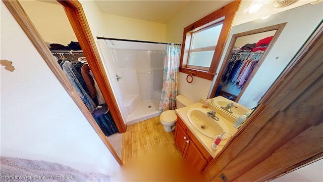 bathroom featuring curtained shower, toilet, vanity, and hardwood / wood-style flooring