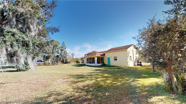 view of yard featuring central air condition unit and a sunroom