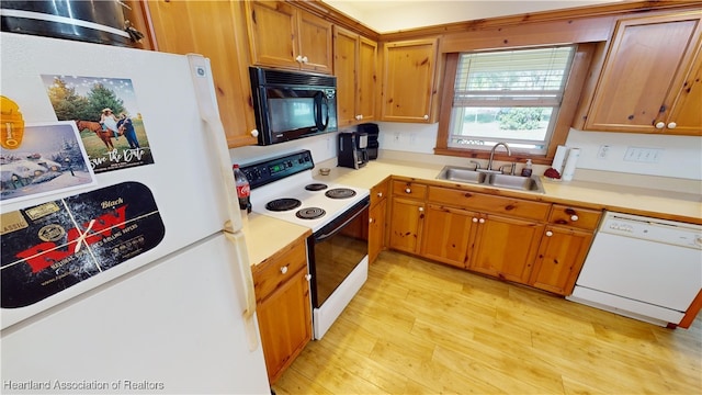 kitchen with white appliances, light hardwood / wood-style floors, and sink