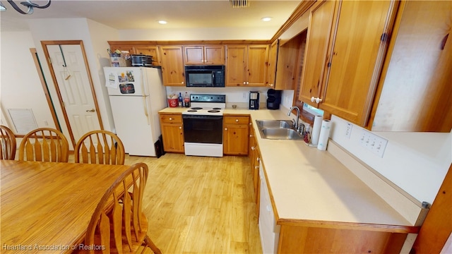 kitchen with sink, light hardwood / wood-style floors, and white appliances