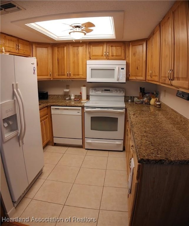 kitchen with visible vents, white appliances, brown cabinetry, light tile patterned floors, and ceiling fan