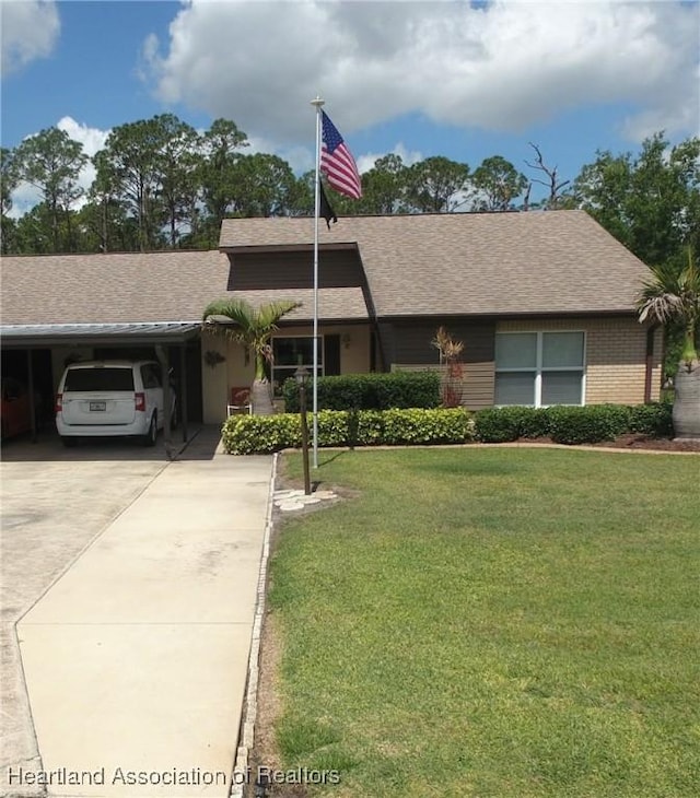 ranch-style home featuring a carport, driveway, a front yard, and roof with shingles