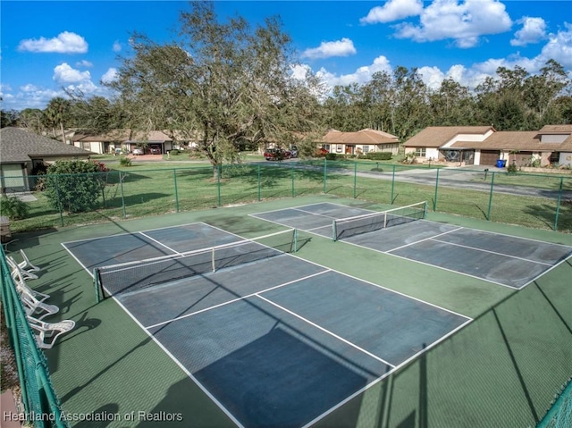 view of tennis court featuring a residential view and fence