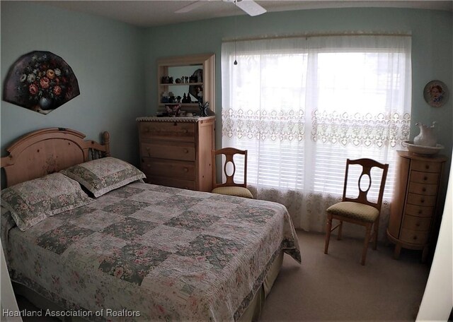 bedroom featuring multiple windows, a ceiling fan, and carpet floors