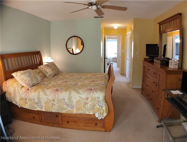 bedroom featuring light carpet, visible vents, a ceiling fan, and a closet