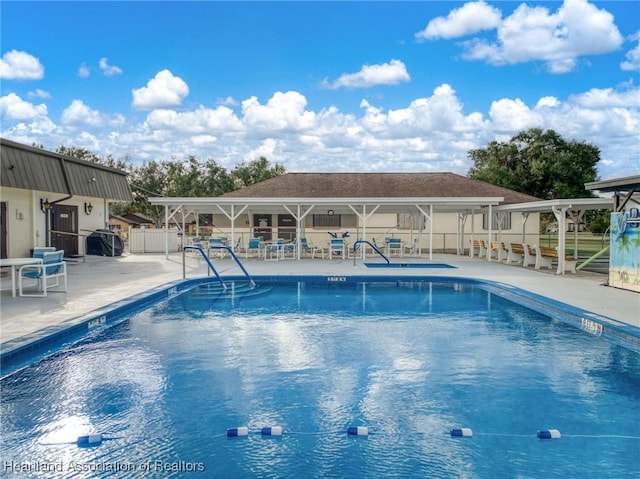 pool with a patio area and fence