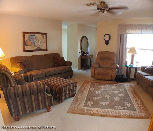 carpeted living area with visible vents and a ceiling fan