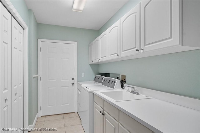 washroom with separate washer and dryer, sink, light tile patterned flooring, and cabinets