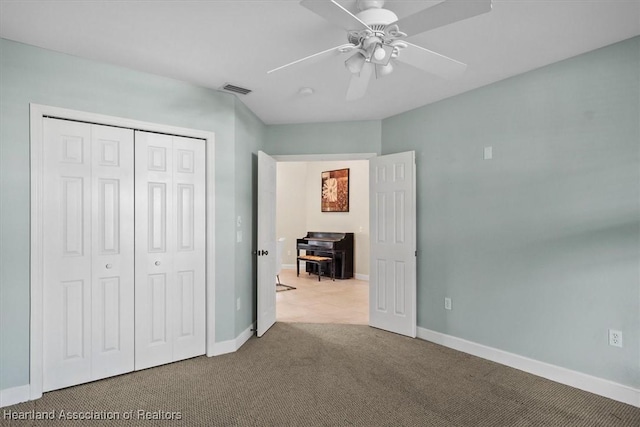 unfurnished bedroom with ceiling fan, a closet, and carpet