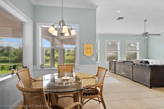 tiled dining area with ceiling fan with notable chandelier and ornamental molding