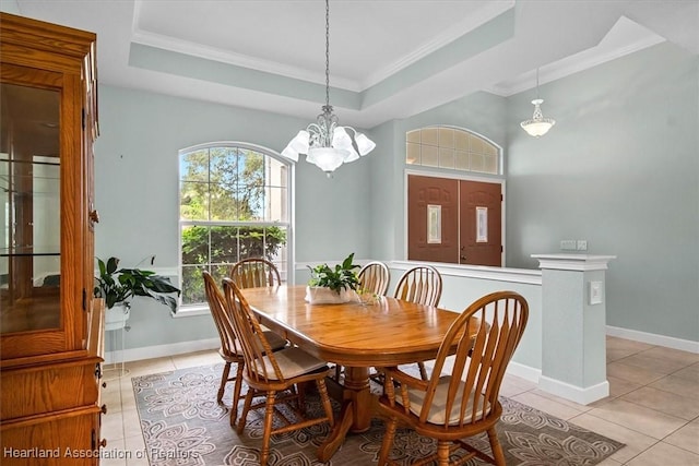 tiled dining area featuring a tray ceiling, an inviting chandelier, and crown molding