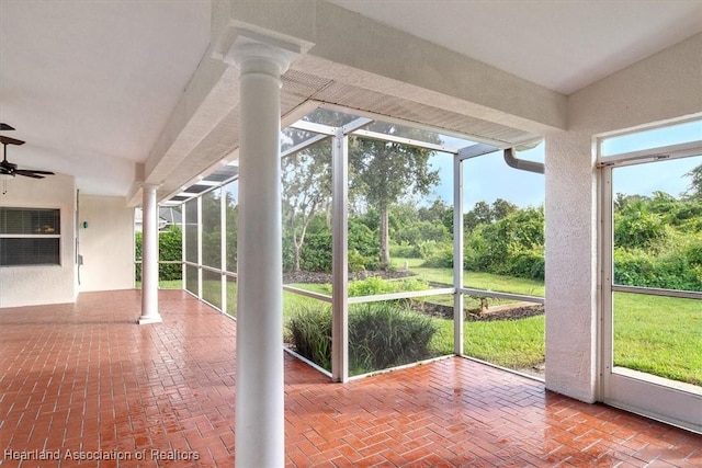 unfurnished sunroom with ceiling fan and lofted ceiling