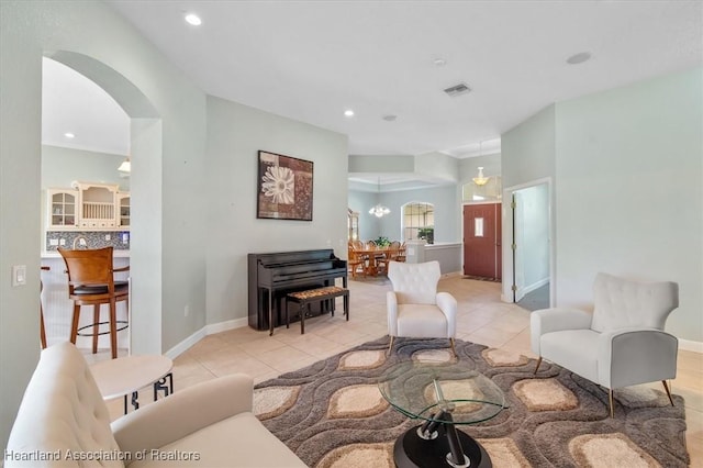 tiled living room with a notable chandelier