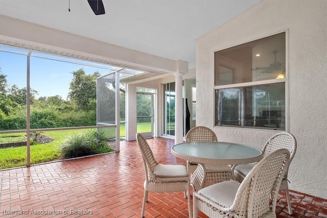 sunroom with decorative columns and ceiling fan