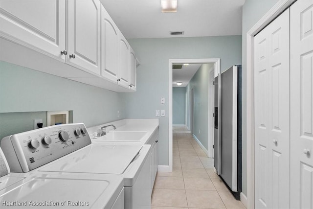 clothes washing area featuring cabinets, separate washer and dryer, sink, and light tile patterned floors