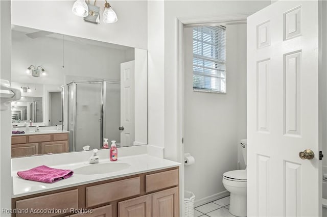 bathroom featuring a stall shower, vanity, tile patterned floors, baseboards, and toilet