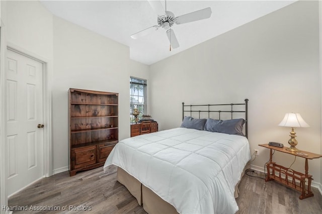 bedroom featuring baseboards, a ceiling fan, lofted ceiling, and wood finished floors