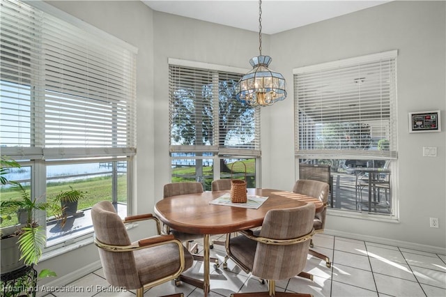 dining area with baseboards, a notable chandelier, and tile patterned flooring