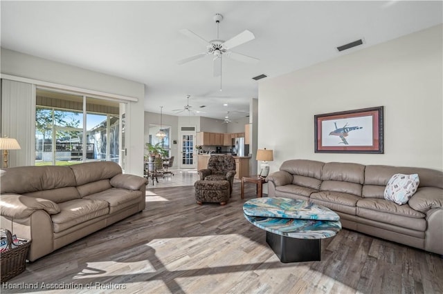 living area featuring ceiling fan, visible vents, and wood finished floors