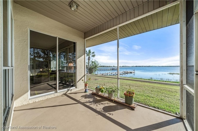 unfurnished sunroom featuring a water view