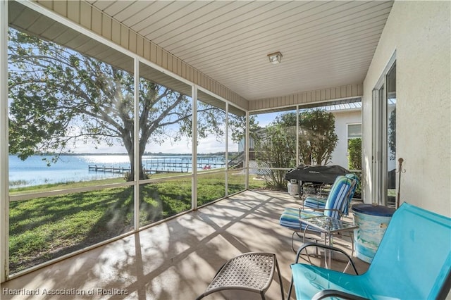 sunroom / solarium featuring a water view
