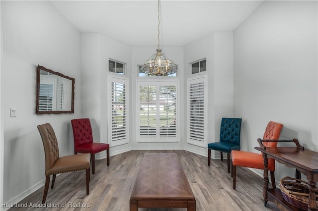 sitting room featuring baseboards, wood finished floors, and a chandelier