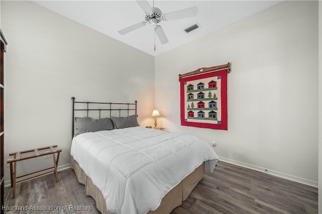 bedroom with visible vents, wood finished floors, baseboards, ceiling fan, and vaulted ceiling