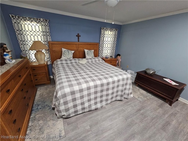 bedroom with ceiling fan, crown molding, and light wood-type flooring