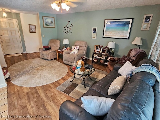 living room featuring a textured ceiling, hardwood / wood-style flooring, and ceiling fan