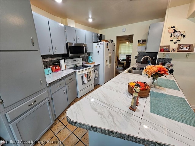 kitchen with white appliances, sink, and light tile patterned floors