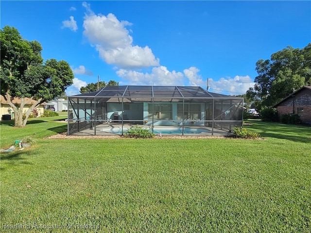 rear view of house with a lanai and a yard