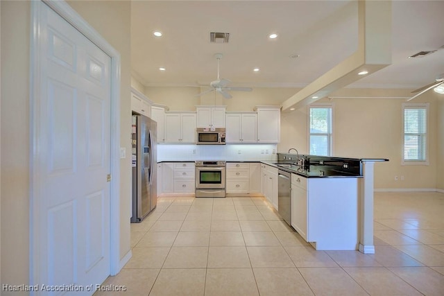 kitchen featuring a ceiling fan, visible vents, appliances with stainless steel finishes, and ornamental molding