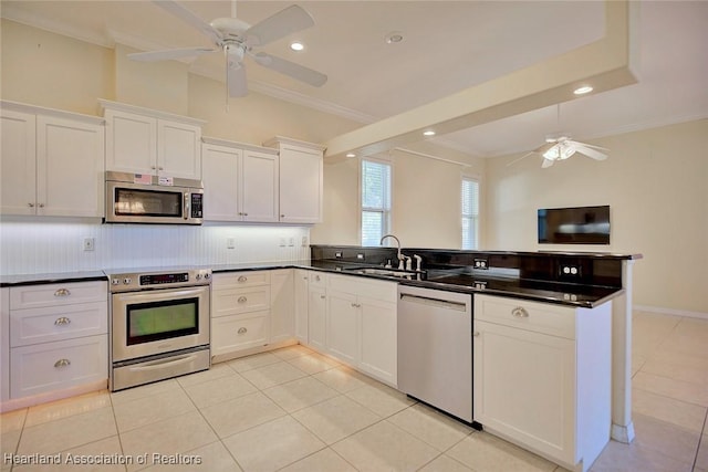 kitchen featuring a peninsula, stainless steel appliances, a ceiling fan, and a sink