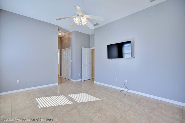 tiled empty room with visible vents, baseboards, and ceiling fan