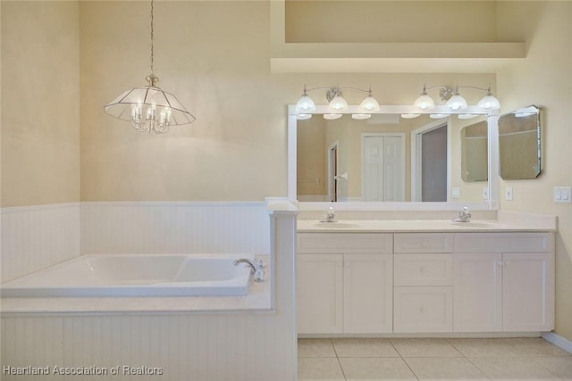 bathroom featuring tile patterned floors, double vanity, a chandelier, and a sink