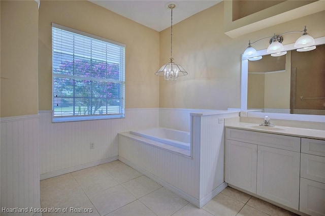 bathroom with a wainscoted wall, a bath, tile patterned floors, a notable chandelier, and vanity