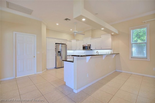 kitchen with visible vents, crown molding, a peninsula, white cabinets, and stainless steel appliances