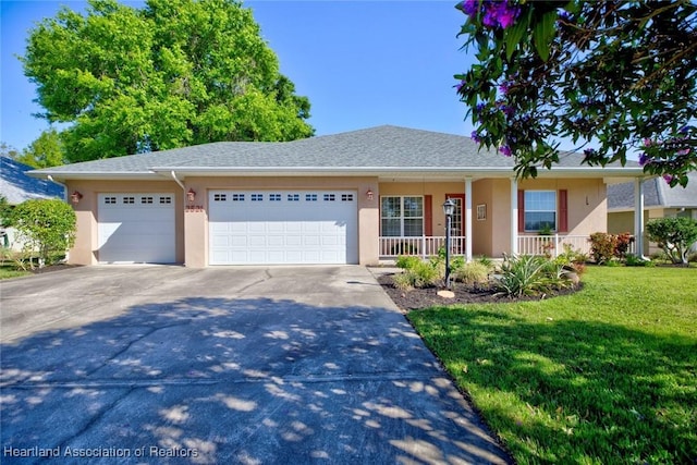 ranch-style house with a front yard, an attached garage, driveway, and stucco siding