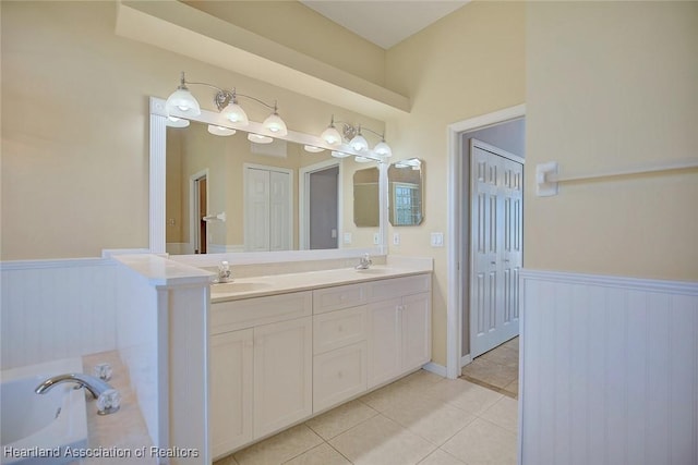 full bathroom with a sink, a wainscoted wall, and tile patterned floors