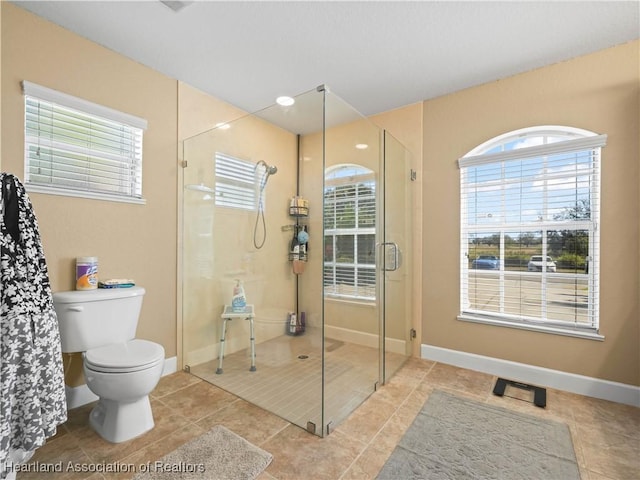 bathroom with tile patterned flooring, toilet, and walk in shower