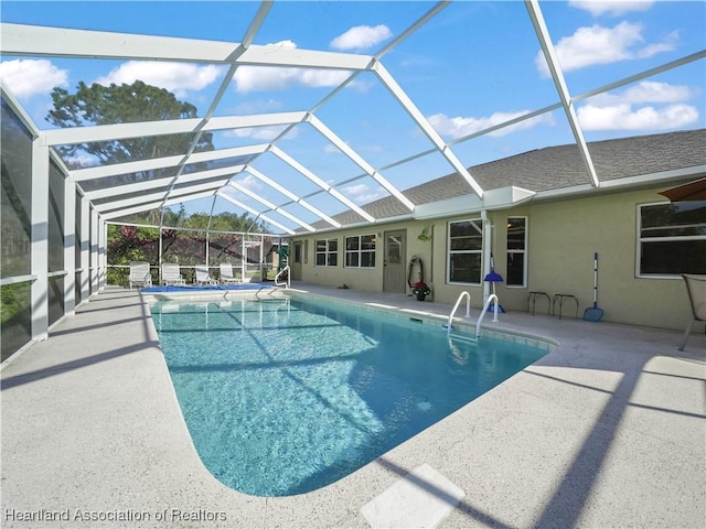 view of swimming pool featuring a patio and a lanai