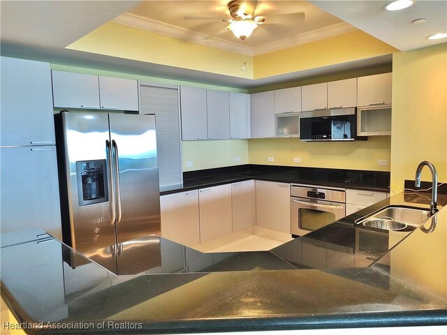 kitchen featuring white cabinets, stainless steel appliances, and ornamental molding